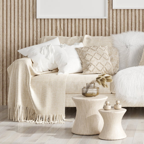 Cozy linen and cotton throws and blankets layered in an inviting, minimal living room to create a warm, elegant atmosphere.